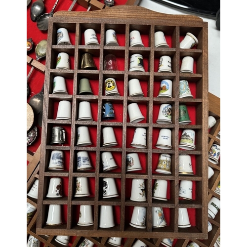 1910R - A large collection of ceramic thimbles & tourist spoons on display racks