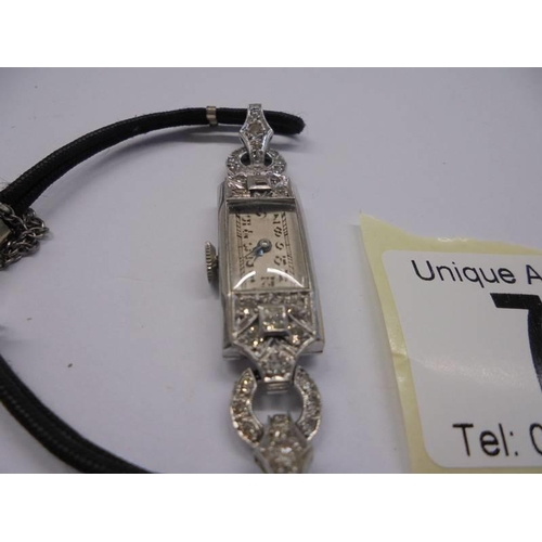 74 - An art deco diamond watch set in platinum with cord strap, 9ct clasp to bracelet, 12.6 grams.