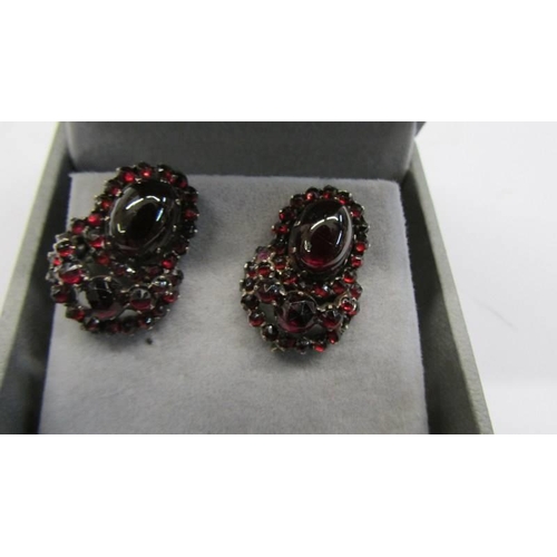 86 - A pair of 19th century garnet stud earrings, cabochon cut garnets, center stone, yellow metal set.