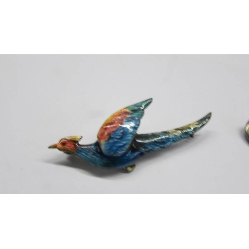 92 - A silver and enamel bird brooch and another featuring deer.