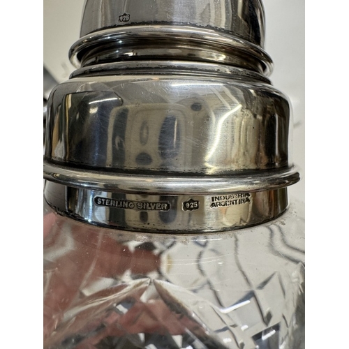 303 - A cut glass cocktail shaker with sterling silver fittings. Height 22.5cm