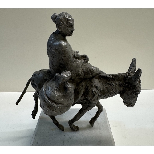 328 - A Spelter figure of a woman on a donkey