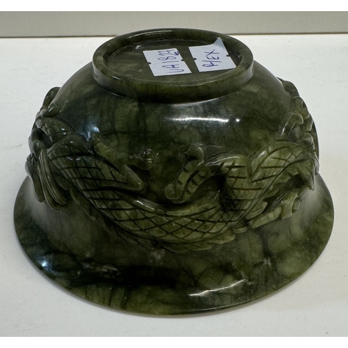 352 - A small antique spinach jade bowl carved around the exterior with archaistic dragons. 13cm diameter