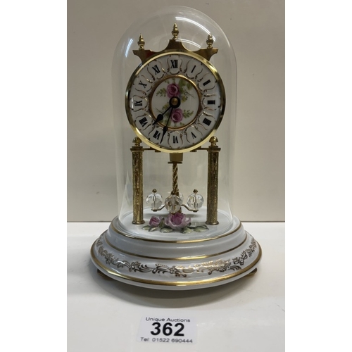 362 - A Quartz anniversary clock on floral ceramic stand with glass dome