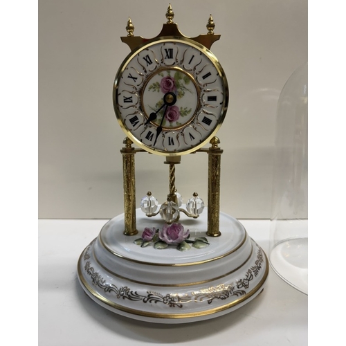 362 - A Quartz anniversary clock on floral ceramic stand with glass dome