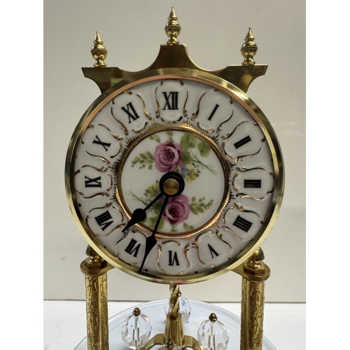 362 - A Quartz anniversary clock on floral ceramic stand with glass dome