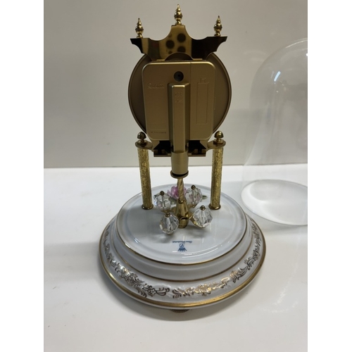 362 - A Quartz anniversary clock on floral ceramic stand with glass dome