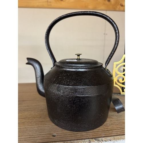 370 - A Victorian cast iron range kettle & a brass & iron trivet