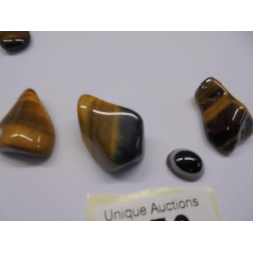 156 - Three polished stone pendants, a brooch and four other polished stones.