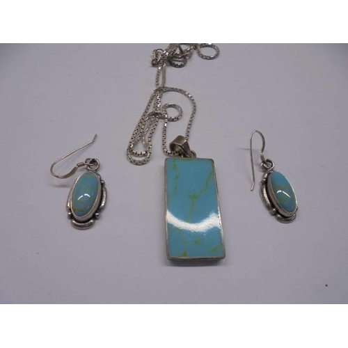 162 - A silver pendant with matching earrings set with turquoise coloured stones.