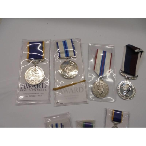 169 - Four Queen Elizabeth II award medals and three miniature examples.