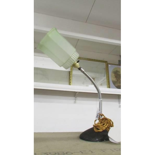 199 - An art deco lamp with chrome flexible column and green glass shade.