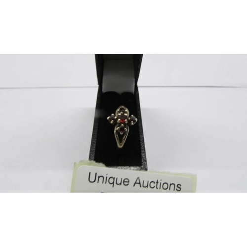 100D - A garnet set ring in a cross desing in 9ct gold, size N, 1.34 grams.