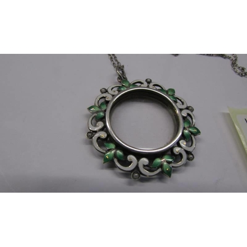 100G - A 19C opening silver locket enamelled with green/white flowers in silver with attached silver chain ... 