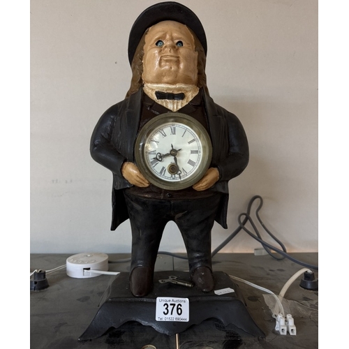 376 - A cast iron figural clock of a man with moving eyes