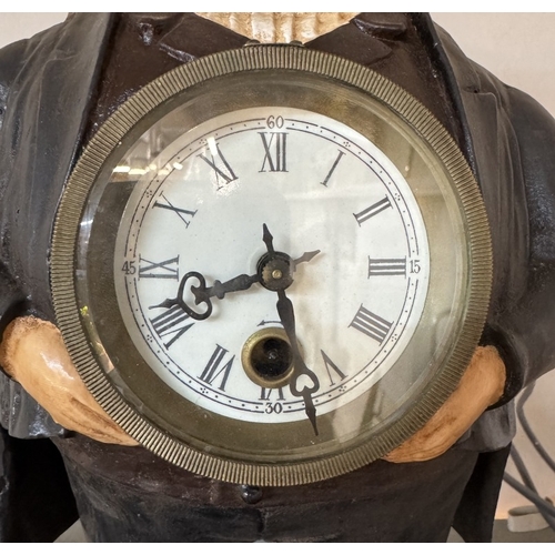 376 - A cast iron figural clock of a man with moving eyes