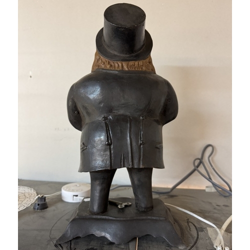 376 - A cast iron figural clock of a man with moving eyes