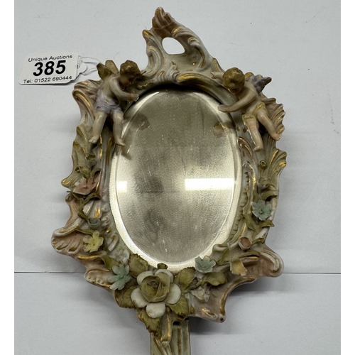 385 - A continental ceramic hand mirror with bevel edge glass