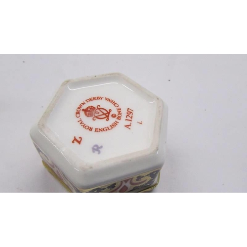 246 - A Royal Crown Derby pill box and a Royal Worcester candle snuffer.