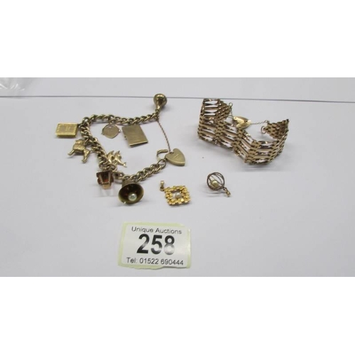 258 - A 9ct gold charm bracelet, a 9ct gold gate bracelet and two loose charms, 39.49 grams.