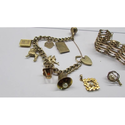 258 - A 9ct gold charm bracelet, a 9ct gold gate bracelet and two loose charms, 39.49 grams.