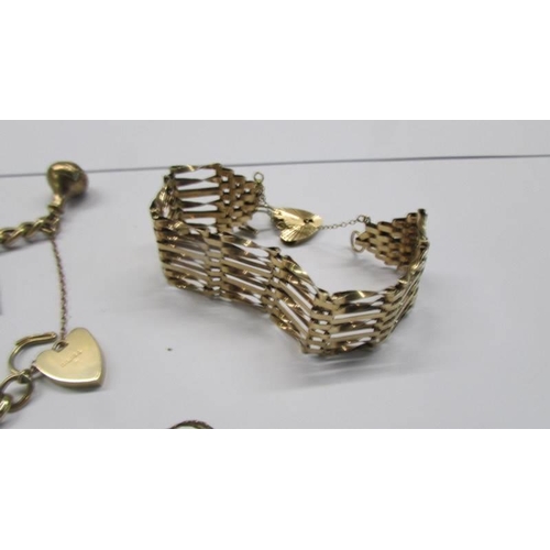 258 - A 9ct gold charm bracelet, a 9ct gold gate bracelet and two loose charms, 39.49 grams.