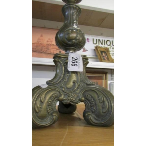 266 - A tall ornate brass candlestick.