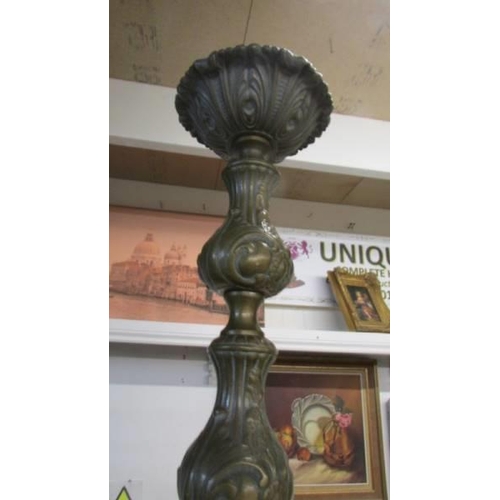 266 - A tall ornate brass candlestick.