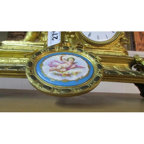 279 - A gilded 19th century mantel clock surmounted cherub and with porcelain panels.