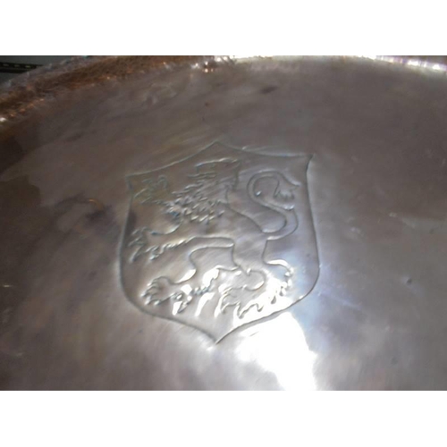 285 - A large oval copper tray with impressed coat of arms.