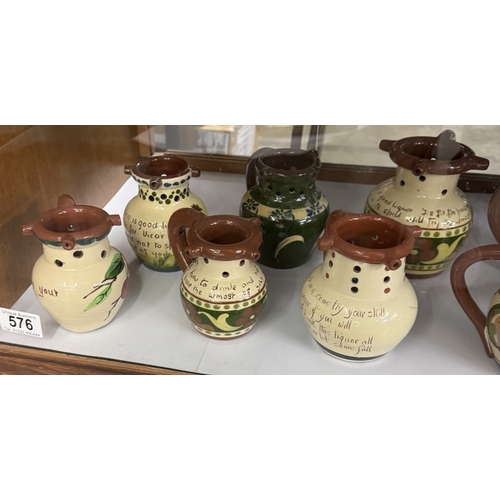 576 - A shelf of vintage Torquay ware puzzle jugs