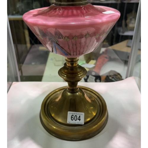 604 - A Victorian oil lamp with brass base, pink art nouveau decorated font on cranberry glass shade