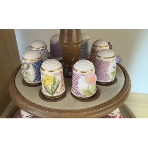 641 - A collection of fine porcelain thimbles on stand