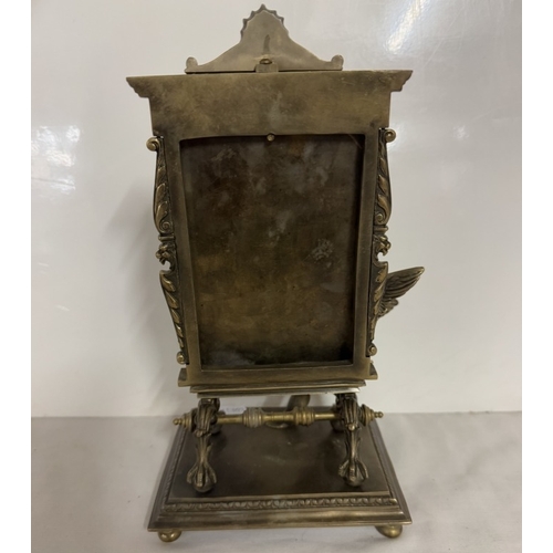 663 - A small metal mirror set as an artists easel with a cherub painting