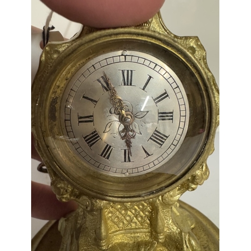 693 - A gilt ormolu clock with verge movement by Thos Whitfield with glass covered escape, height 18cmment