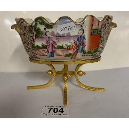 704 - A porcelain frilled bowl centrepiece on gilded legged base featuring Chinese painted scene