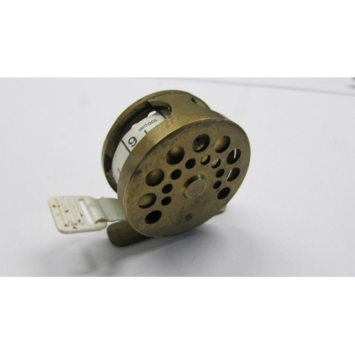 291 - A novelty brass sewing tape measure in form of a fishing reel.