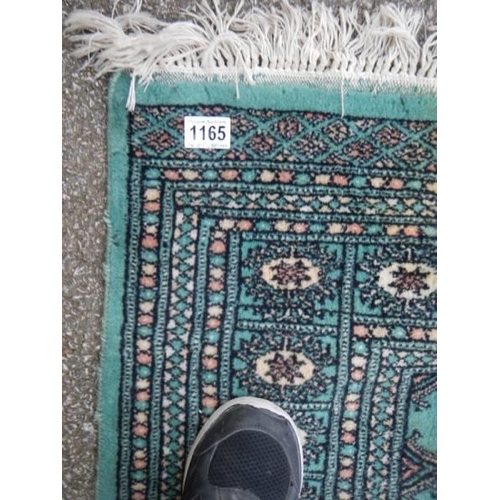 1165 - A green patterned rug, 130 x 180 cm