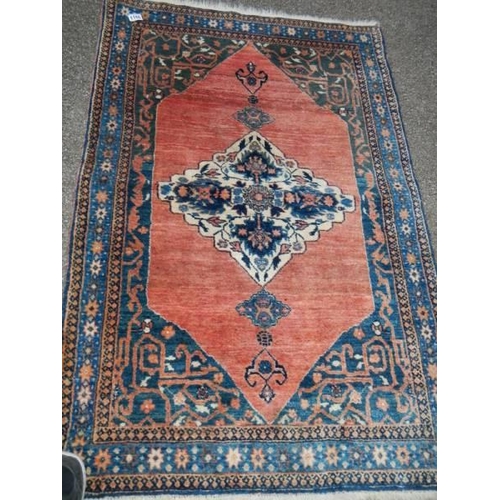 1166 - A red patterned Persian rug. 85 x 130 cm