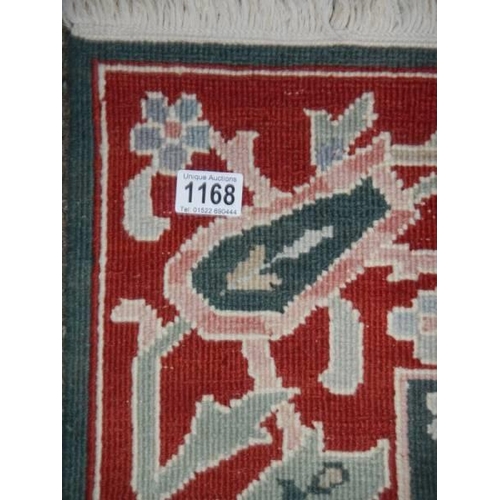 1168 - A red patterned rug, 116 x 182 cm.