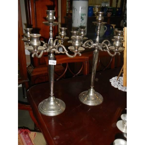 1192 - A pair of tall white metal candelabra.