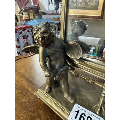 1685 - An ornate brass mirror of a cherub in front of an artists easel, base 12cm x 10cm, height 23cm