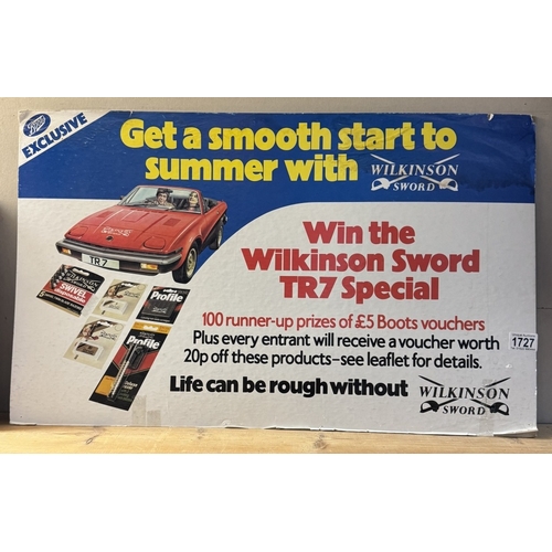 1727 - A vintage Wilkinson sword, win a Triumph TR7 paper on card advertising sign/poster, 73cm x 44cm