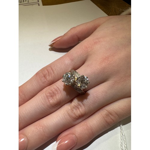 52 - An 18ct gold ring set two x two carat diamonds, size O, total weight 7.4 grams.