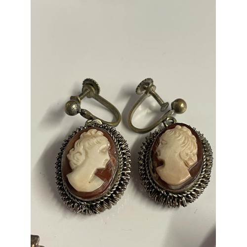 21 - Two shell cameo brooches in silver mounts, a pair of white metal cameo earrings and a cameo ring.