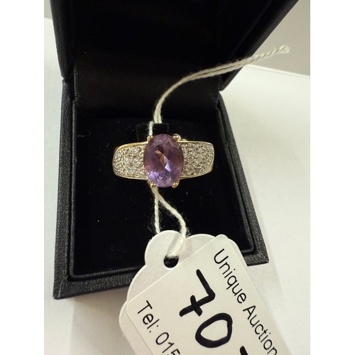 70J - A gold ring set with amethyst tiny clear stones