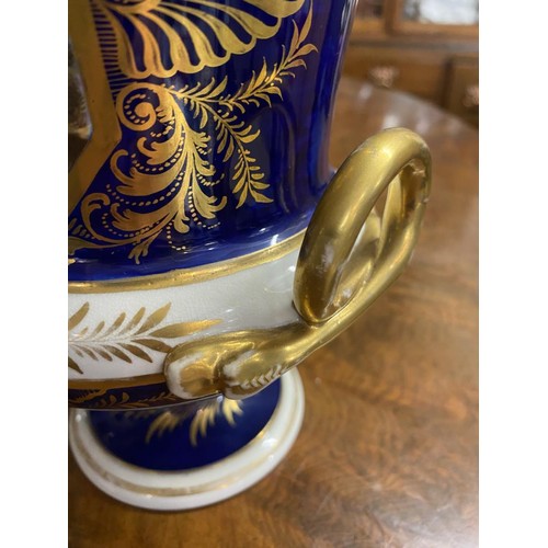 677 - A Derby cobalt ground vase of campana form with gilt snake handles, painted with a traveller in a wo... 