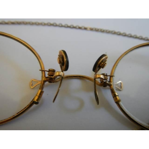 509 - A pair of Pince Nez marked V10-12k with attached chain, in good condition.