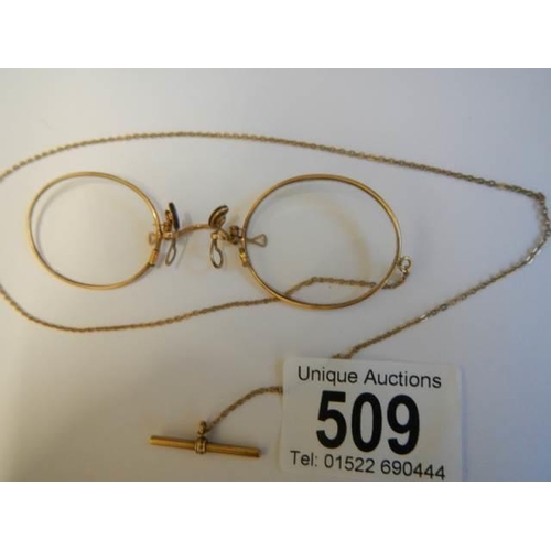 509 - A pair of Pince Nez marked V10-12k with attached chain, in good condition.