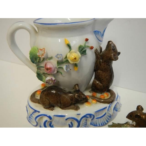 516 - A porcelain cream jug surmounted mice and another mouse figure.